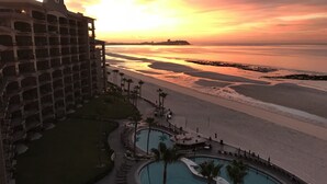 Un hôtel doté d’une piscine, d’un accès à la plage et offrant une vue sur le coucher de soleil.