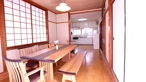 A traditional Japanese-style room with tatami flooring, a wooden dining table, and shoji screens. - Mahoroba (Motobu)