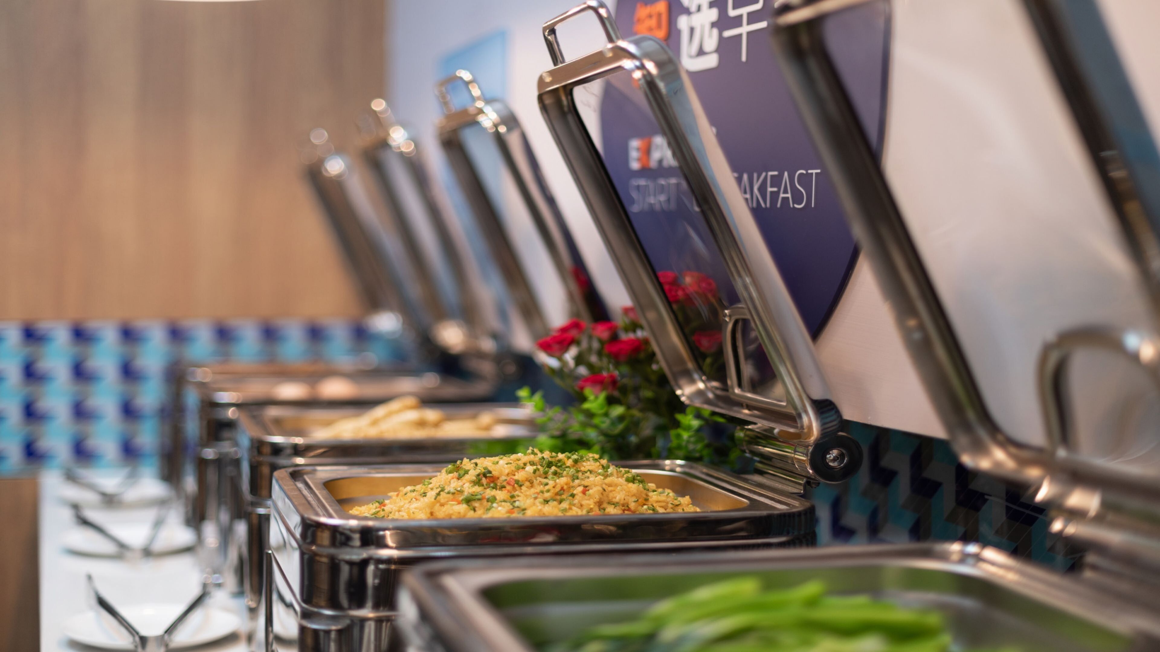 A buffet setup with multiple serving stations, each with a metal container and a lid.