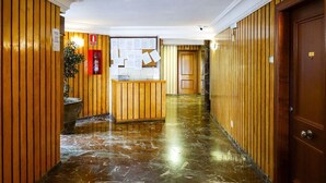 A hallway with wooden paneling, a reception desk, and a door at the end. - Great apartment with pool in Los Boliches (FUENGIROLA)