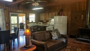 Un intérieur de chalet chaleureux comprenant un salon, un coin repas et une cuisine.