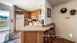 A kitchen with wooden cabinets, a granite countertop, and a bar stool.