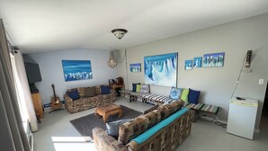 Un soggiorno con divani a motivi decorativi, un tavolino da caffè e un grande quadro raffigurante montagne.