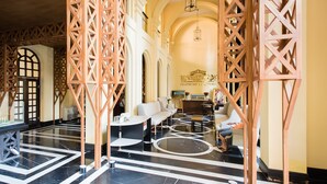 A spacious lobby with a marble floor, a seating area with sofas and tables, and a decorative wooden partition. - Venetian Signature by GrandisVillas (Pattaya)