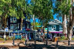 A street scene with a pharmacy, a botanical chemist shop, and a clothing store. - Luxury Apartment at Sea Temple Palm Cove 2 Bed 2 Bath (Palm Cove)