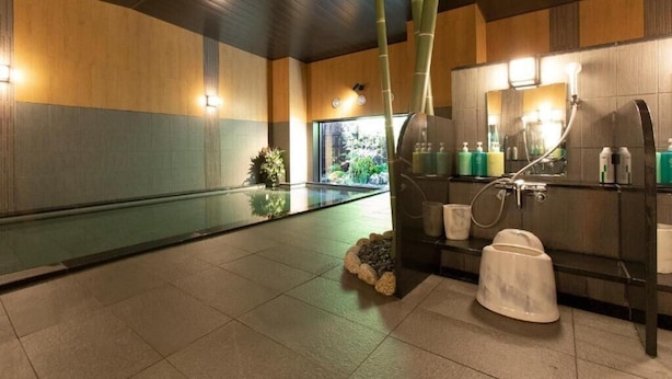 Een moderne badkamer met glazen scheiding, bamboe decoratie en een grote spiegel.
