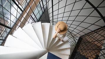 A spiral staircase with a person wearing a hat.