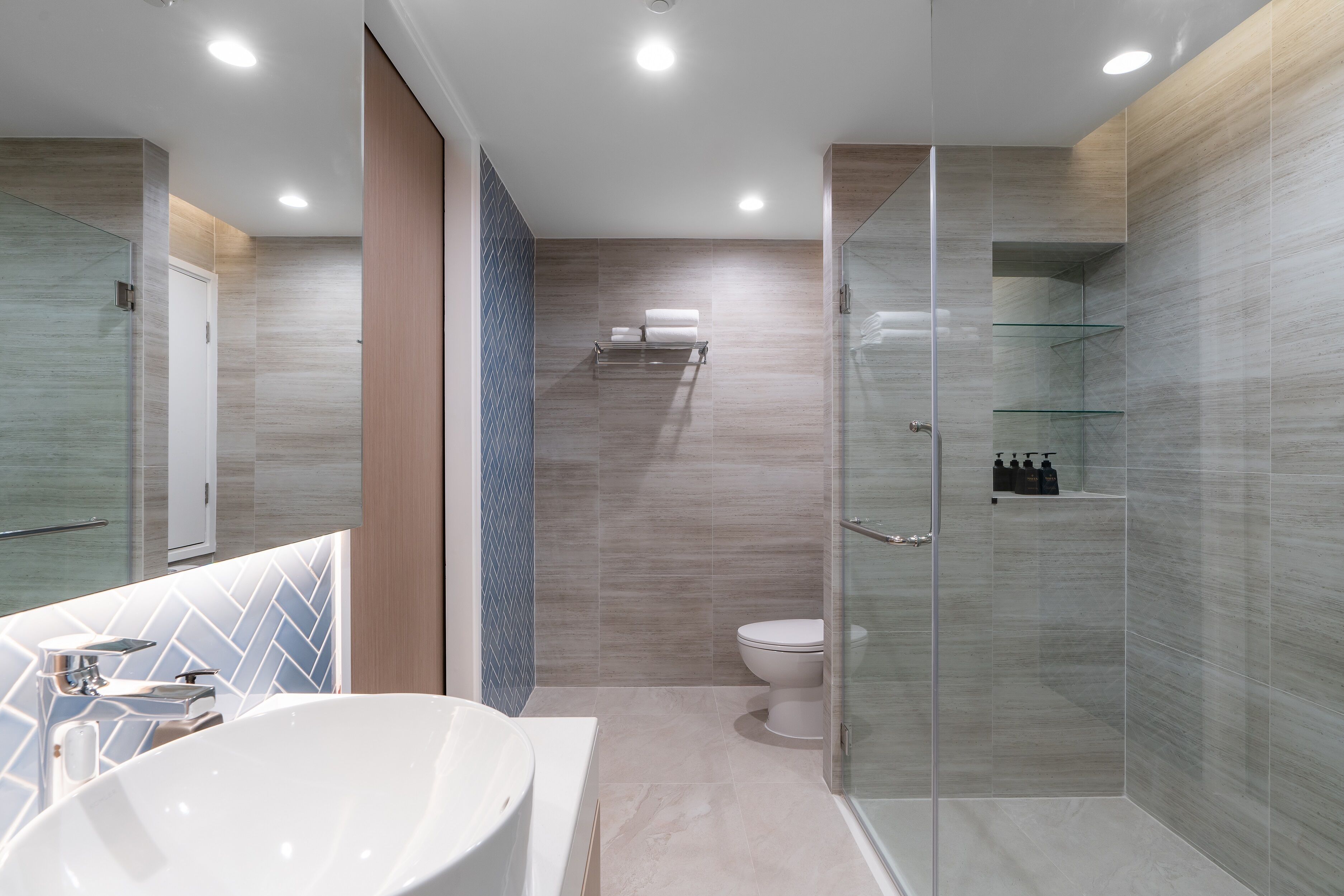 A modern bathroom with a freestanding bathtub, a glass-enclosed shower, and a toilet.
