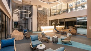 A spacious lobby with modern seating, a staircase, and a reception area. - Maven Stylish Hotel Hua Hin (Hua Hin)