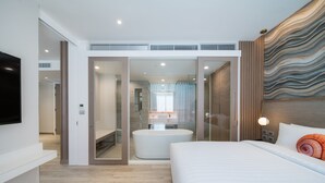 A modern hotel room with a large bed, a bathtub, and a television on the wall. - Maven Stylish Hotel Hua Hin (Hua Hin)
