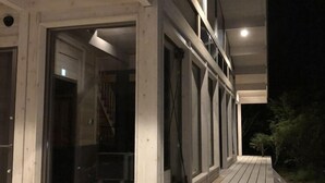 A wooden deck with a glass door leading to an interior space. - Polar House Nishikaruizawa 1 (Karuizawa)