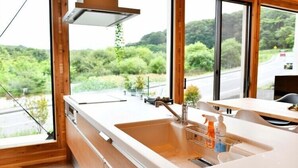 A kitchen with a large window, a sink, and a countertop. - Polar House Nishikaruizawa 1 (Karuizawa)