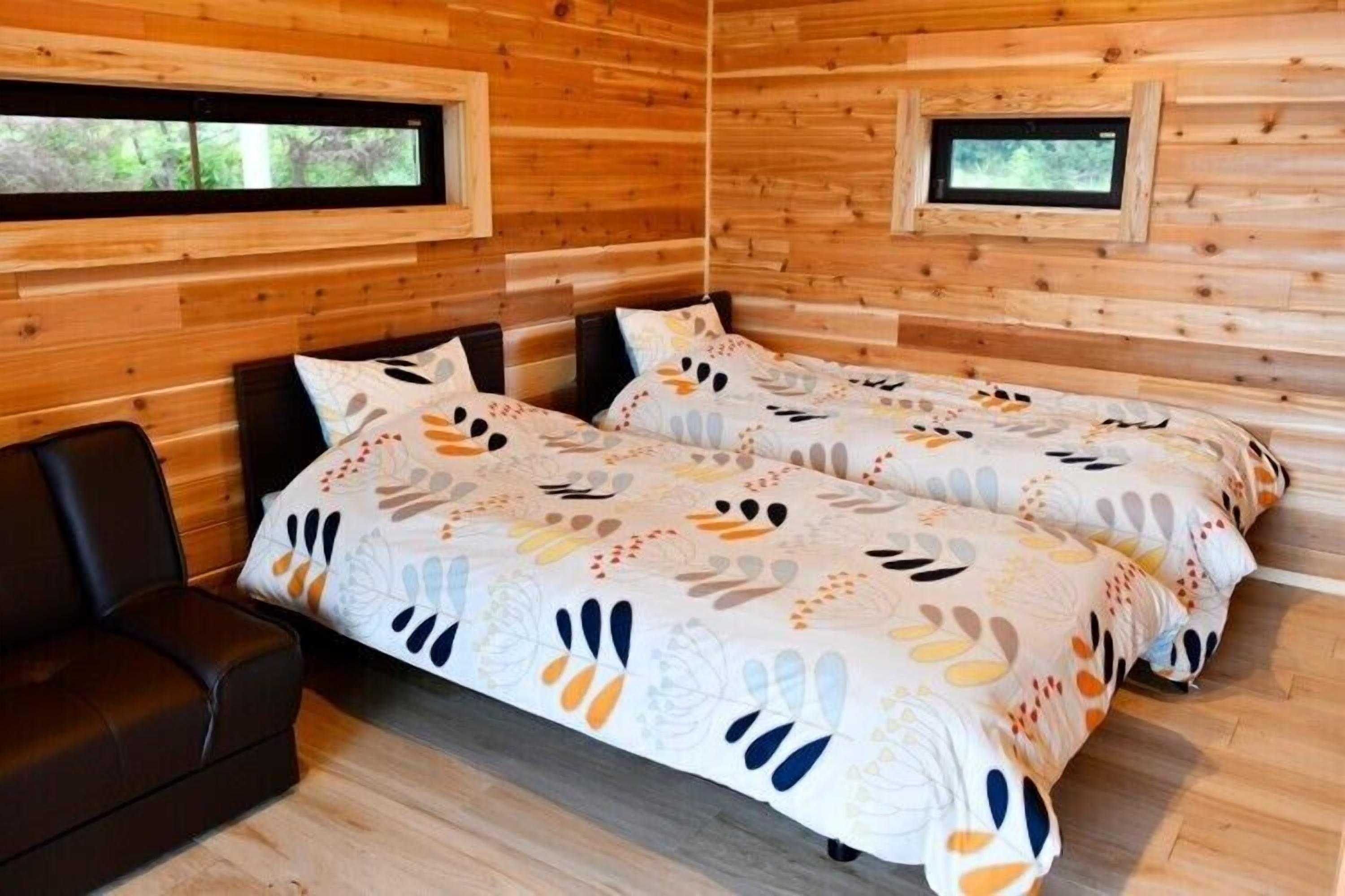 A cabin with two beds, a sofa, and a window.