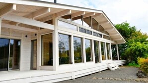 A modern house with a covered porch, large windows, and a chimney. - Polar House Nishikaruizawa 1 (Karuizawa)