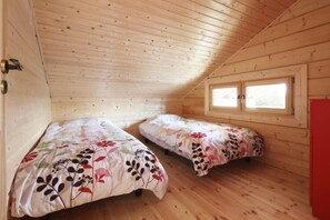 A cabin with two wooden beds, a sloped ceiling, and a window. - Polar House Karuizawa 1 (Karuizawa)