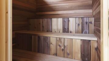 A wooden sauna with benches and a skylight.
