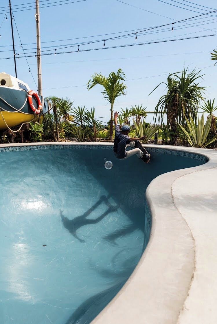 Una persona patinant sobre el vèrtex corbat d'una piscina.
