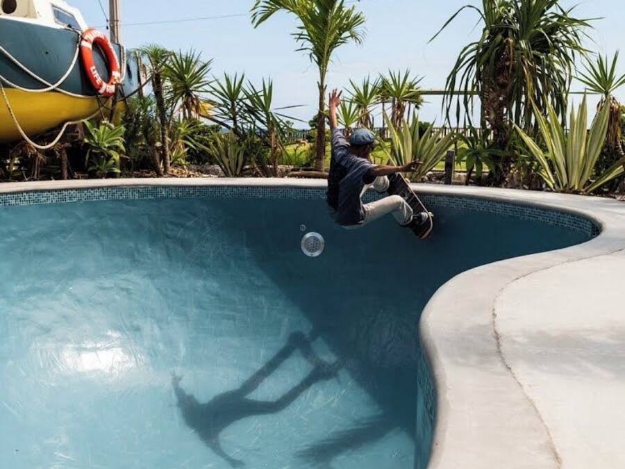 Una persona patinant sobre el vèrtex corbat d'una piscina.
