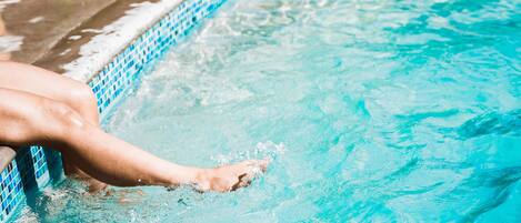 A pool with clear blue water and a tiled edge.