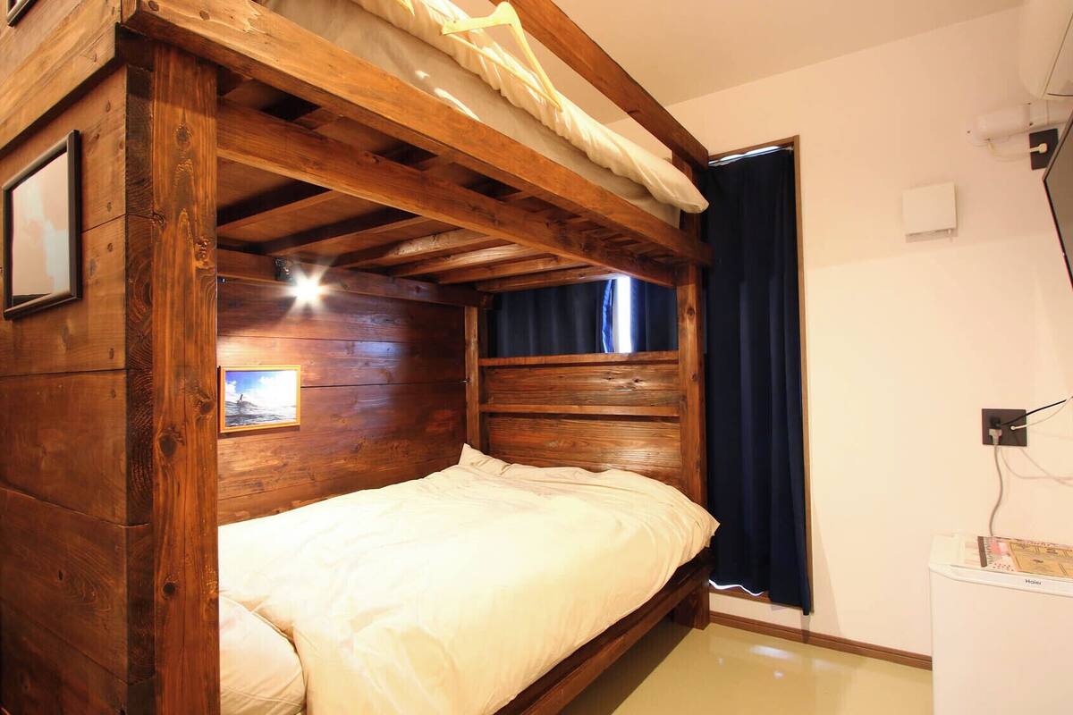 A wooden bunk bed with a picture frame and a small window.