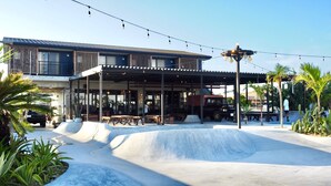 Un edificio con zona de estar al aire libre techada, estacionamiento y una pista de skate.