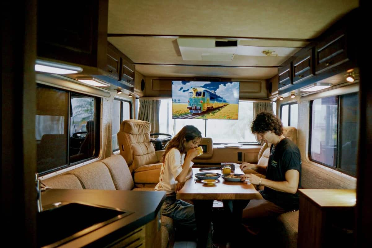 A dining area with a table, chairs, and a television screen displaying a train.