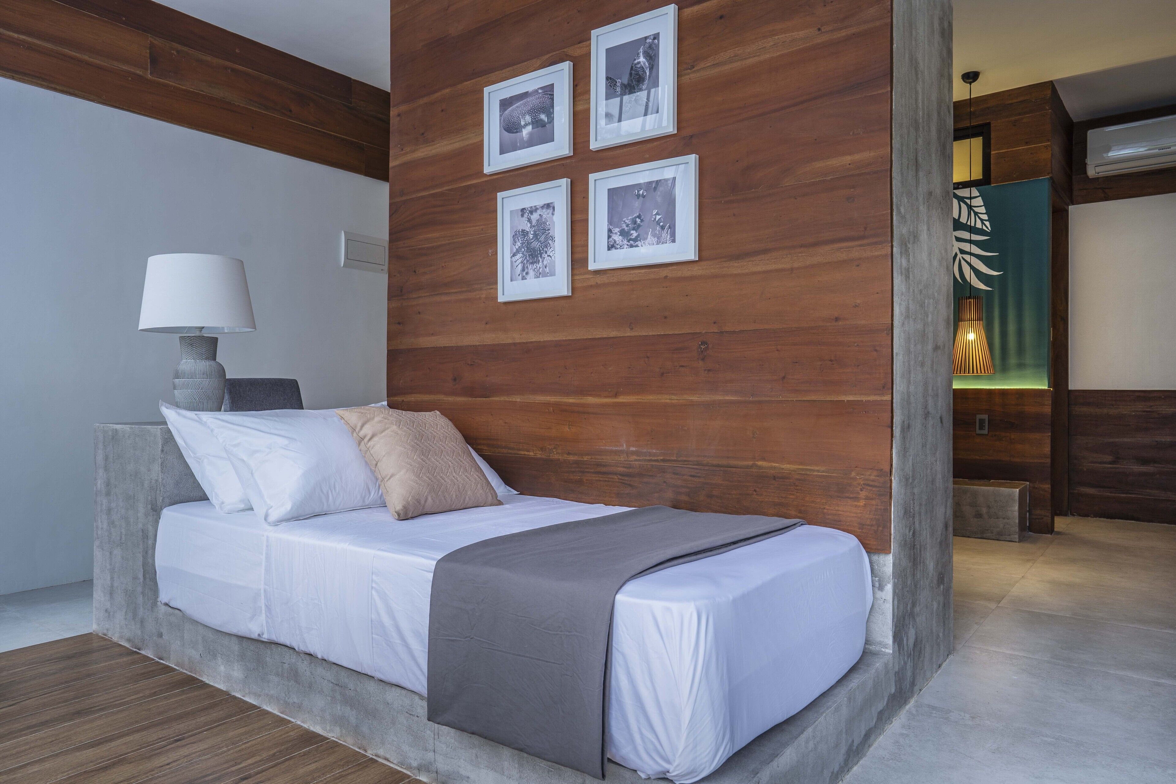 Un dormitorio moderno con una cama, una lámpara y cuatro cuadros en la pared.