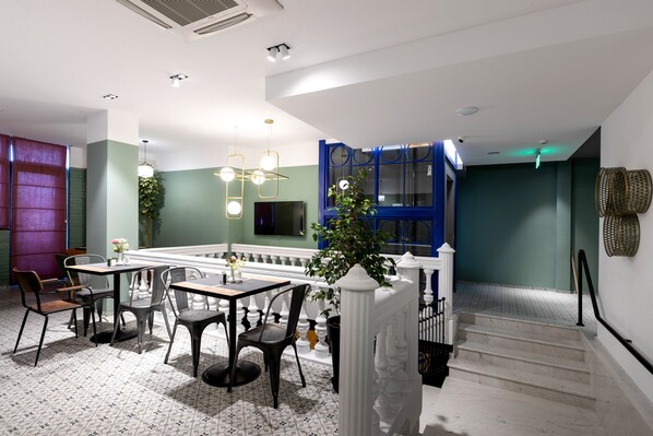 A dining area with a table and chairs, a staircase, and a view of the outside.