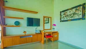 Una habitación moderna con un escritorio de madera, televisión, un reloj y un cuadro decorativo.