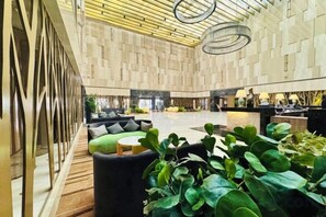 A spacious lobby with a high ceiling, seating areas, and a reception desk. - NCEC Jinyuan Hotel (TIANJIN)
