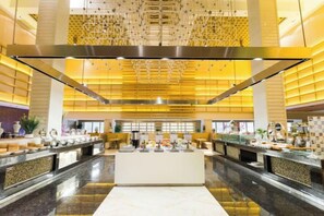 A spacious lobby with a central reception desk, multiple seating areas, and a high ceiling with a patterned design. - NCEC Jinyuan Hotel (TIANJIN)