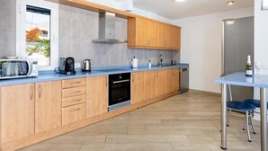 A modern kitchen with wooden cabinets, a built-in oven, a coffee maker, and a dishwasher. - Stunning Villa Mila in Madroñal, heated pool! (Adeje)