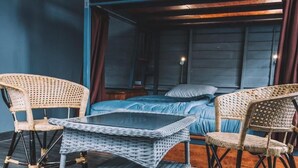 A room with a bed, two wicker chairs, a small table, and a nightstand. - Time Sabai 134 - Hostel (Bangkok)