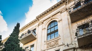 A historic building with ornate architecture, large windows, and a storefront with visible merchandise. - The Merchant Baku (Baku)