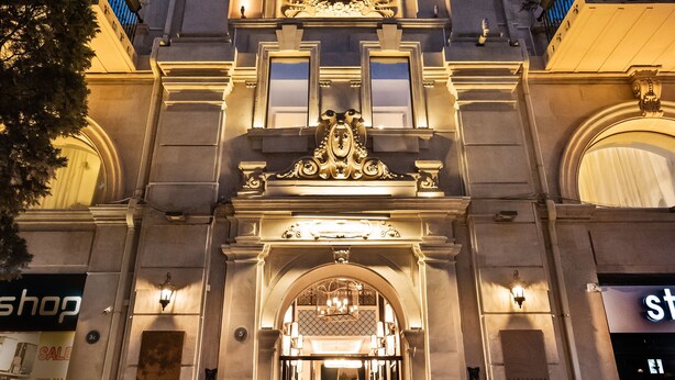 A grand entrance with a large arched doorway, decorative elements, and a well-lit facade. - The Merchant Baku (Baku)