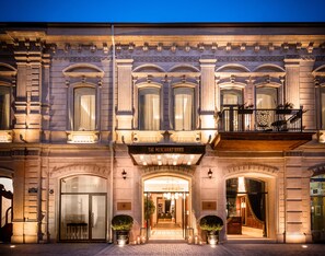 A historic building with a grand entrance, a sign reading "The Merchant Bakhu," and a balcony with ornate railings. - The Merchant Baku (Baku)