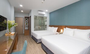 A hotel room with two beds, a wooden nightstand, a glass shower enclosure, and a small wooden cabinet with a vase of flowers. - Piano Hotel (Ho Chi Minh City)