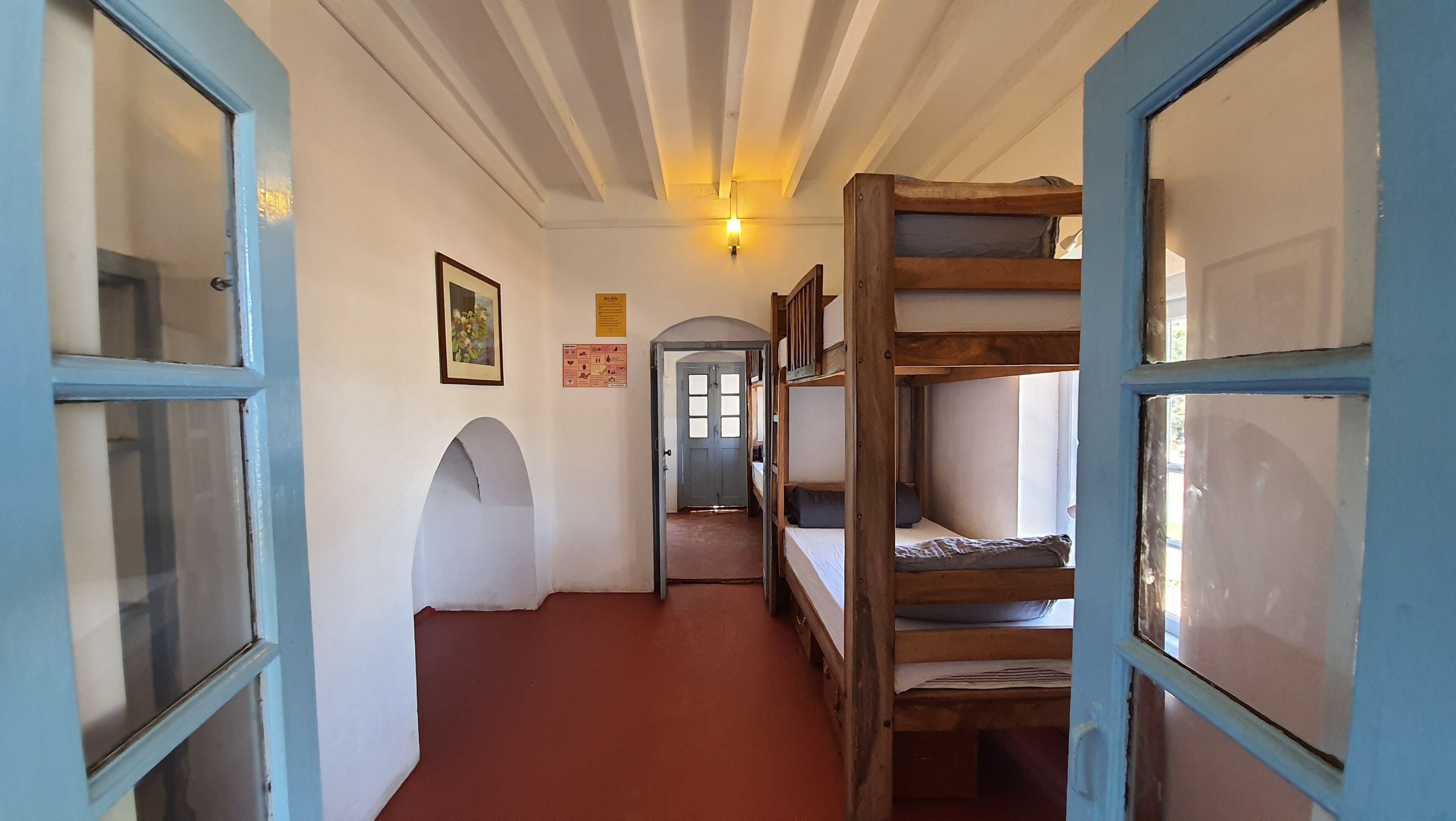 A narrow hallway with bunk beds on one side and a door at the end.