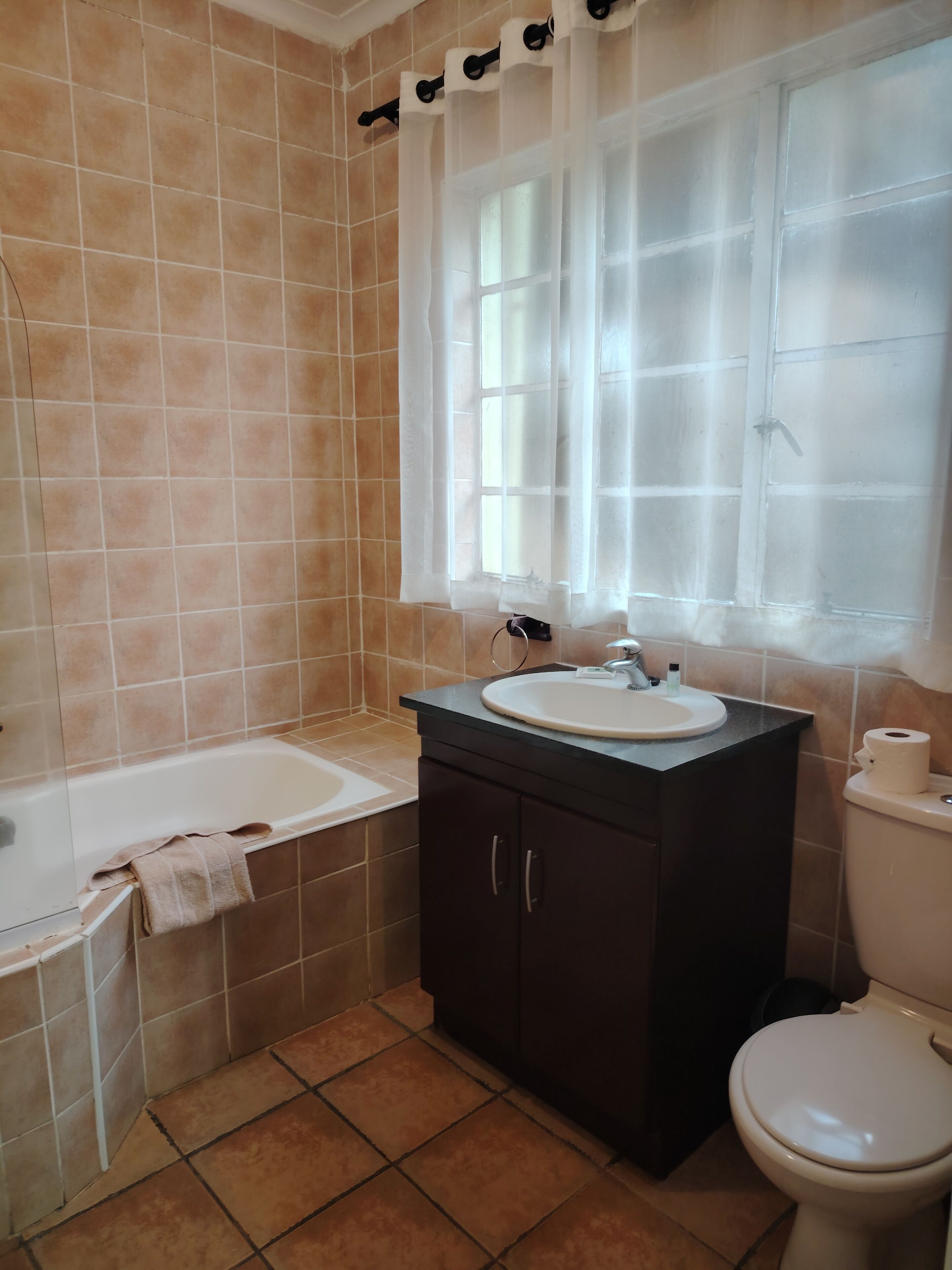 Un baño con bañera, lavamanos e inodoro.