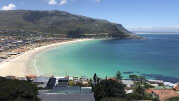 Experience the charm of a coastal town nestled between green hills and a picturesque beach.