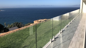 Un balcon offrant une vue dégagée sur l’océan et les montagnes lointaines.