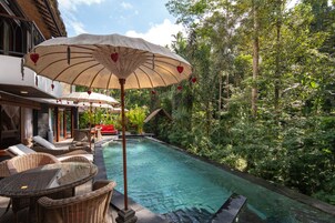 Una piscina al aire libre, sillones reclinables de piscina