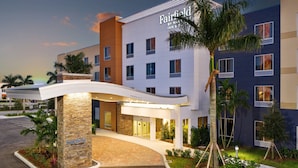 A modern hotel entrance with a clear entrance, a stone pillar with the hotel name, and a covered walkway. - Fairfield by Marriott Inn & Suites Deerfield Beach Boca Raton (Deerfield Beach)