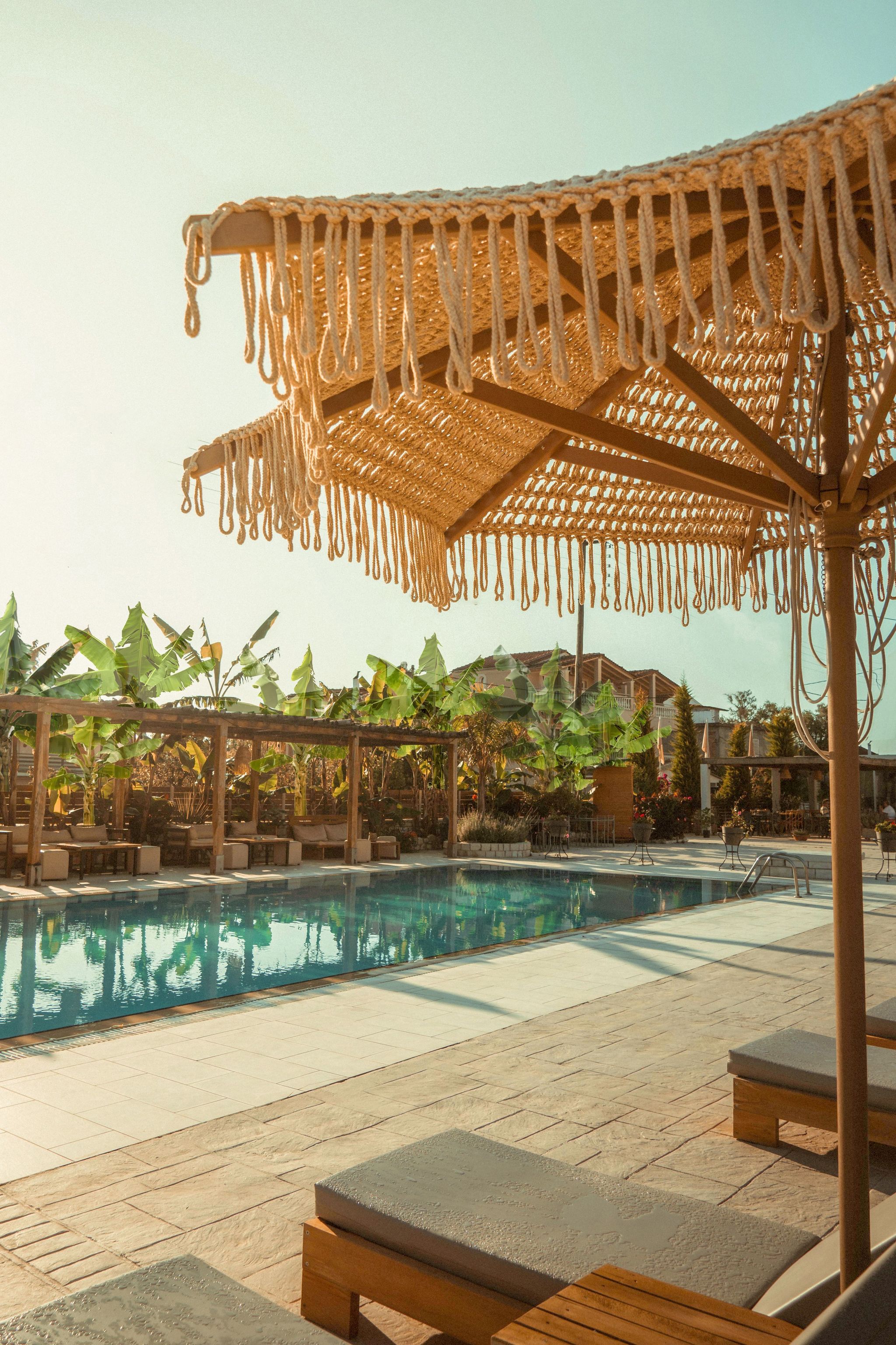 A poolside area with lounge chairs, a pool, and a canopy structure.