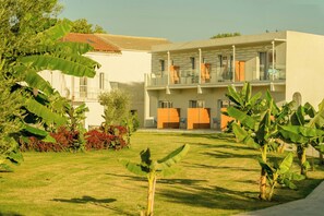 Um hotel moderno com telhado plano, área de estar coberta ao ar livre e um gramado bem cuidado.