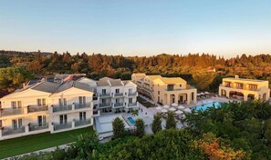Ein Resort mit mehreren Villen, einem Swimmingpool und bewaldeter Kulisse.