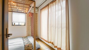 A room with a bed, a window with patterned curtains, a ceiling with exposed beams, and a door. - Villa Traditional Designer House Shin Itabashi (Tokyo)