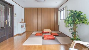 A room with tatami mats, a low wooden table, and cushions. - Villa Traditional Designer House Shin Itabashi (Tokyo)
