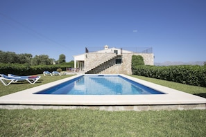 Une piscine avec un escalier en pierre menant à une maison.