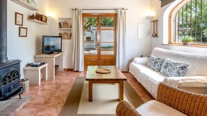 Una sala de estar acogedora con chimenea, televisor, sofá y mesa de comedor.